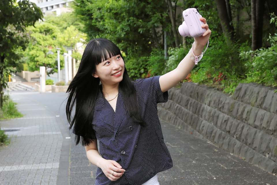 チェキを目線より上に構えて撮影している様子