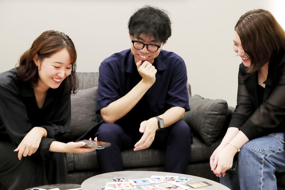 アプリを見ながら笑顔で話している3名を撮影した写真
