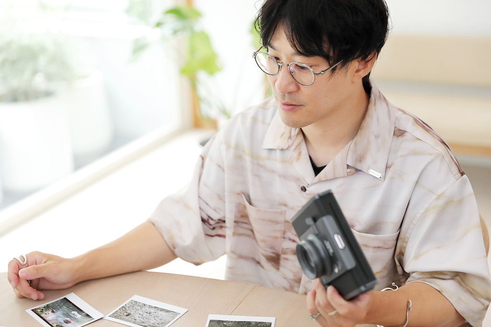 山口さんが撮影したチェキを見ている様子を撮影した写真