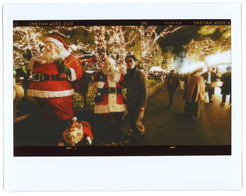 サンタのオブジェの前で慎太郎さんを撮影したチェキプリント