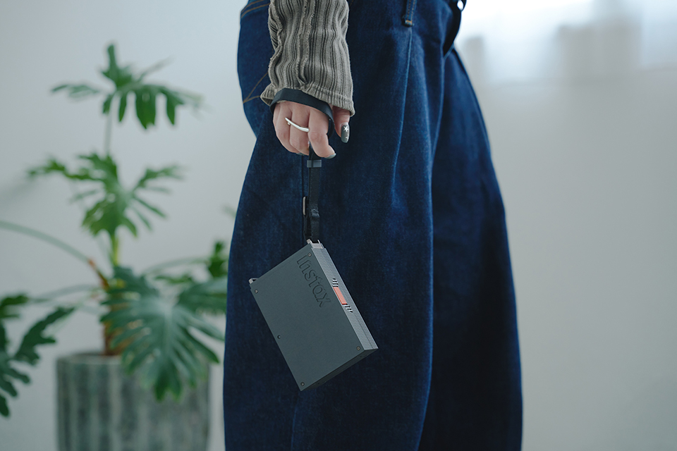 付属ストラップを手の甲にかけてmini Link+を持っているNAKAKI PANTZさん