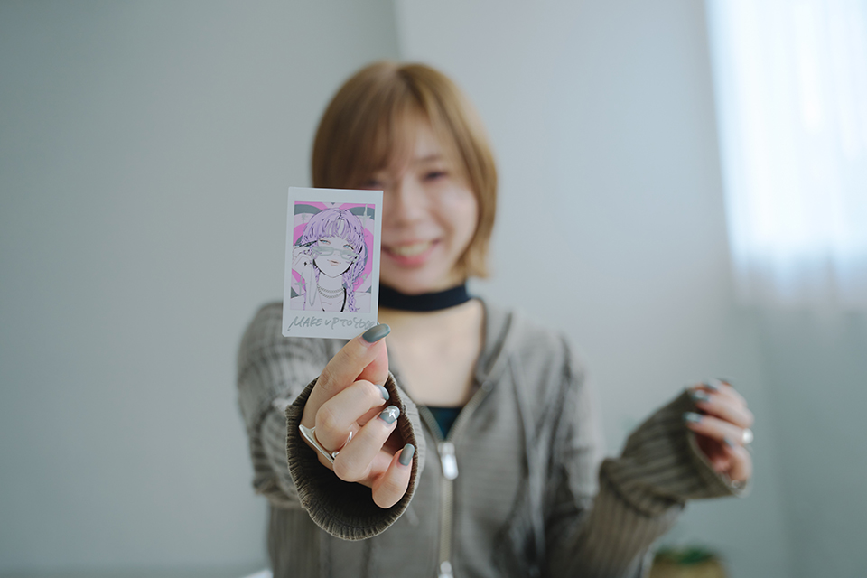 デコレーションしたチェキプリントを持ったNAKAKI PANTZさん