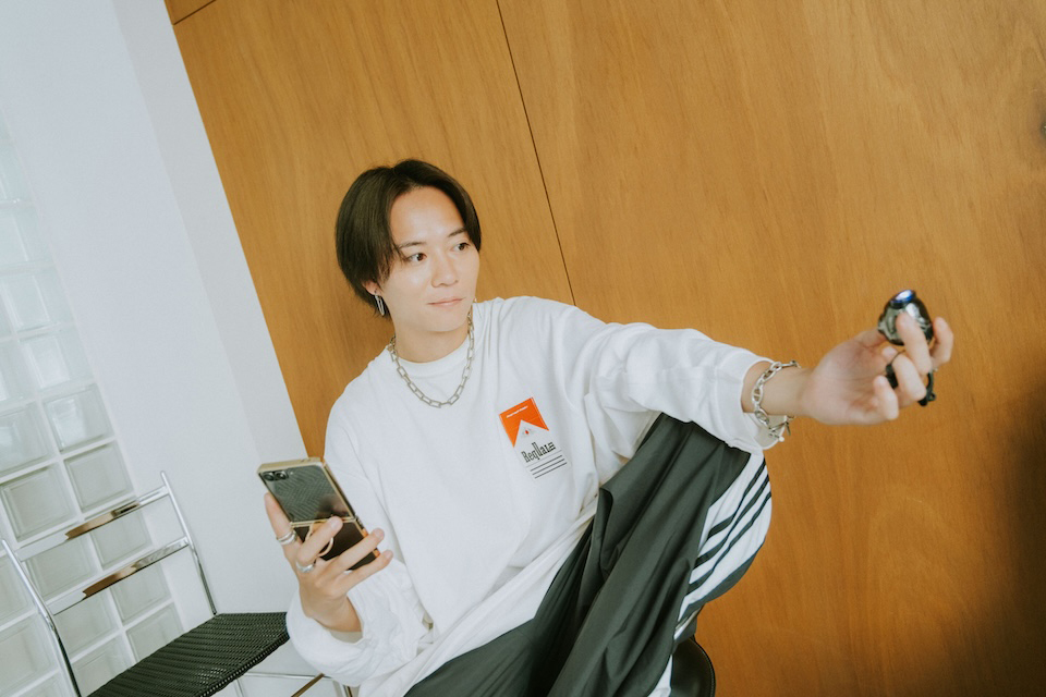 椅子に座ってセルフィーを撮影する杉本さん