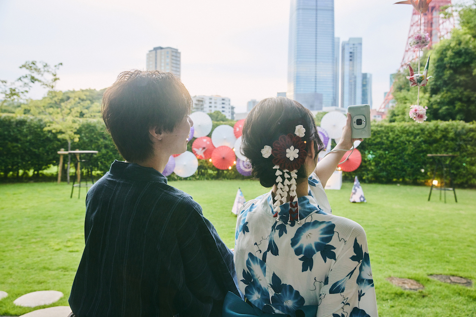 浴衣を着た男女がmini LiPlayでセルフィーを撮影している写真