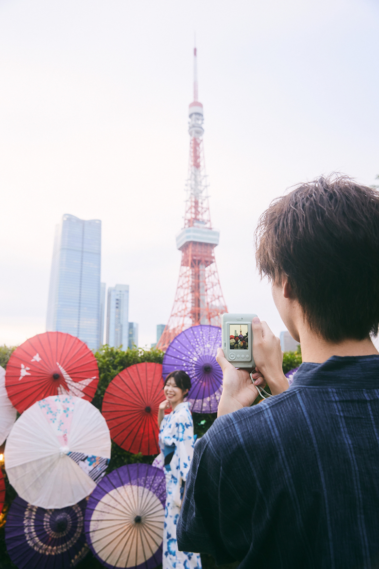 和傘が並べられたフォスポットで浴衣を着た女性をmini LiPlayで撮影している写真