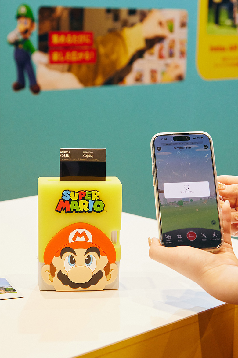 「スーパーマリオ」のシリコンケースをつけた「instax mini Link 3™」てプリントしている様子